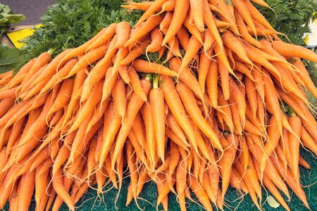 A bunch of carrots for sale at a marketの写真素材