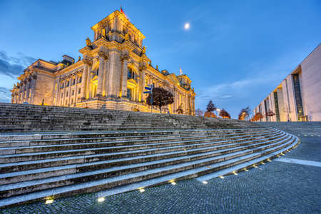 The illuminated Reichstag in Berlin seen from the river Spree at dawnのeditorial素材