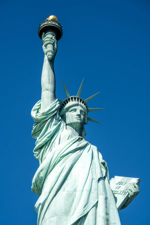 Closeup on the famous Statue of Liberty in New York in front of a blue skyの写真素材