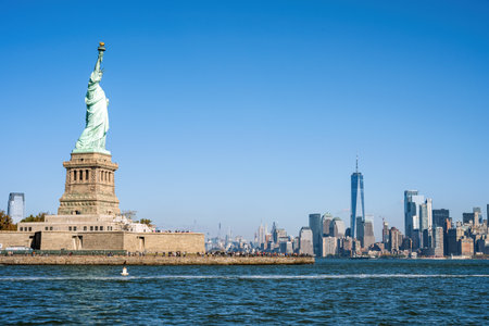 The famous Statue of Liberty in New York with the skyline of Manhattan in the backの写真素材
