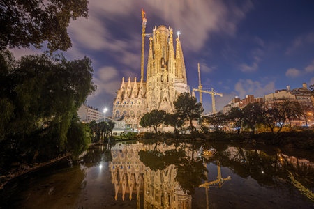 The illuminated Nativity Facade of the famous Sagrada Familia in Barcelona at blue hourの写真素材