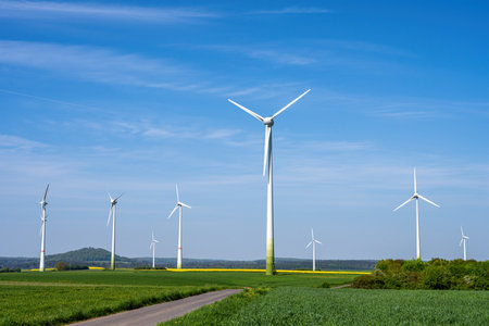 Modern wind turbines with a small country road seen in Germanyの写真素材