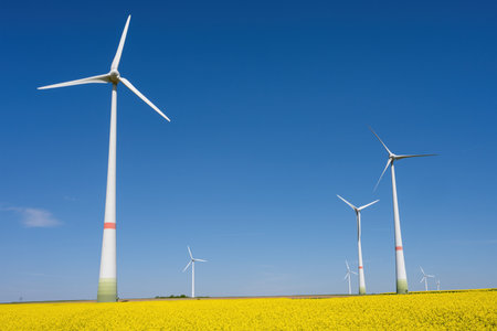 Wind turbines in a field of blooming canola lakes in Germanyの写真素材