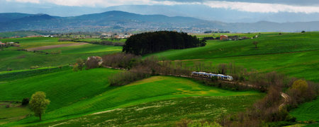 Modern train travelling through green hills