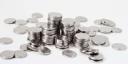 Metal coins stacks close-up photographed on white backgroundの写真素材