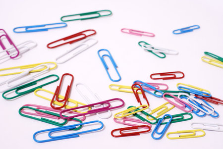 Group of color paperclips on white paper background