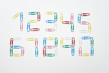 Numbers from zero to nine made with multicolored paper clips photographed on white background