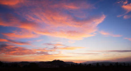 Beautiful red clouds in blue sky with silhouette of Campobasso castleの写真素材