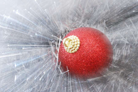 Abstract view of red christmas ball on bright silver tinselの写真素材