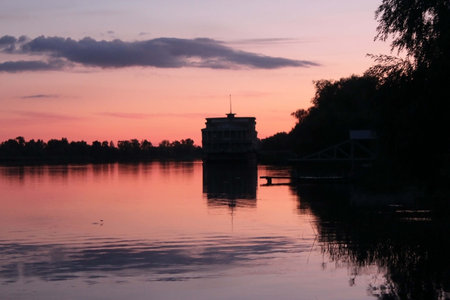 the river at sunset, purple clouds, a pink sunset, a ship at the pier.の写真素材