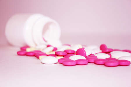 Colorful pills and vitamins scattered from a bottle of bubble background for text.の写真素材