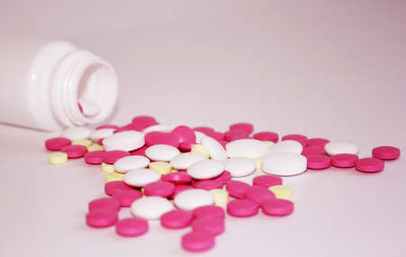 pink pills scattered from the bottleの写真素材