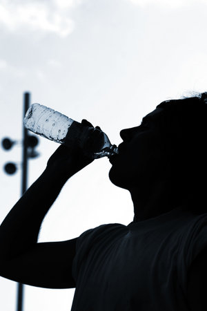a thirsty boy is drinking water after match. With copyspaceの写真素材