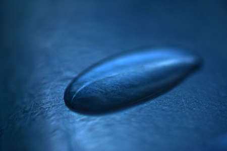 A close up of a drop of water on blueの写真素材