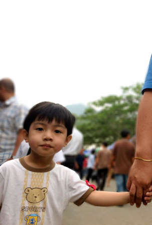 A little boy holding his mothers handの素材