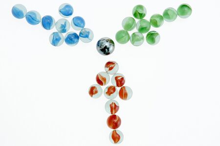 Green, Red, and Blue marbles arranged in arrows pointing towards the center.の写真素材