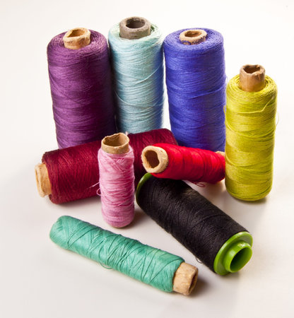 Multicolored sewing threads on white background