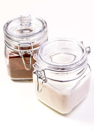 Glass jars with lids of cofee and sugar isolated on white backgroundの写真素材
