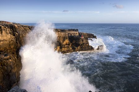 sunset on the coast. waves crash on the rock. Cascais Portugalの写真素材