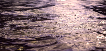 Violet reflections on the water surface, movements of light on the waves. Perfect background image....