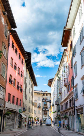 View of one of the main pedestrian streets in the historic center of Trento, Italy. Historic buildings and people walkingのeditorial素材