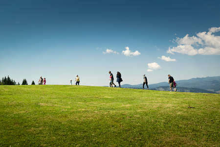 Tourists stroll on the green pastures of the Dolomites. Blue sky. Cima Campo, ArsiÃ¨, Bellunoのeditorial素材