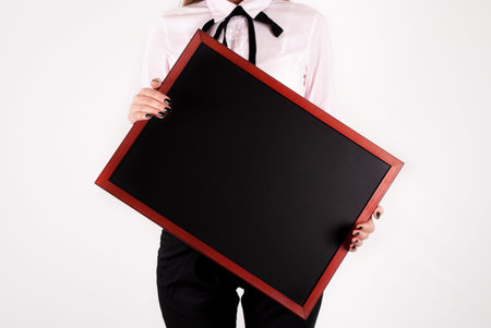 Woman holding black board in hands. Close up