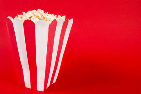 Box of popcorn on red background and space for textの写真素材