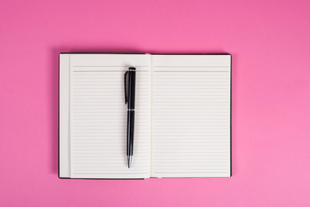 Notes and pen top view on a pink background