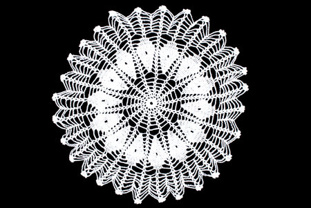 White round lace tablecloth isolated on black backgroundの写真素材