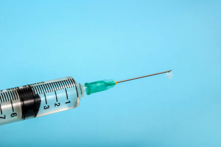 Injection with medicine and needle isolated on a blue background, medical concept