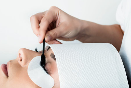 Girl make silk eyelashes in a beauty salon