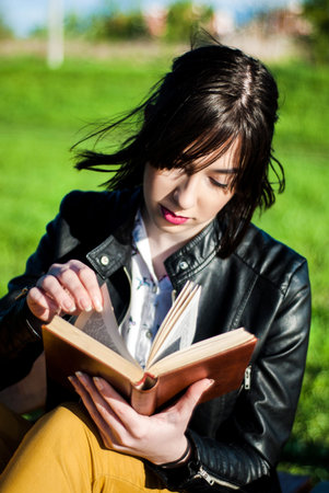 Girl reading a book on a sunny spring day in natureの写真素材