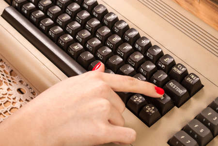 Woman finger press button on old computer keyboardの写真素材