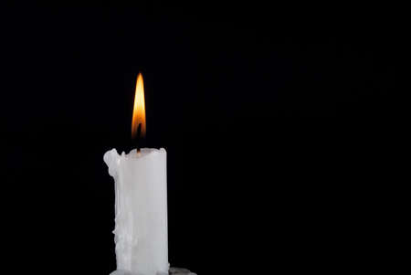 Paraffin Candle burning and old candlestick isolated on black background and space for textの写真素材