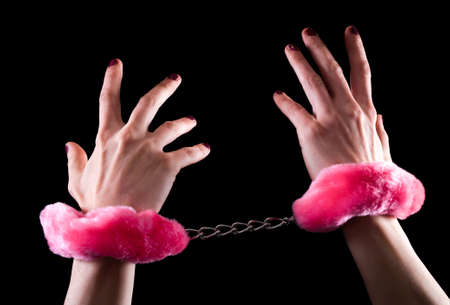 Young women hands in handcuffs with pink fur. Close upの写真素材