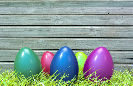 Colorful Easter eggs in green grass and wooden plank in background. 3D illustration