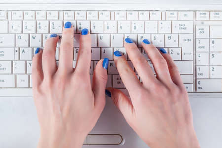 Woman hand working on white laptop keyboard. Top view, Close upの写真素材