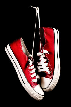 Red sneakers hanging on black surface. Retro fashion. Close upの写真素材