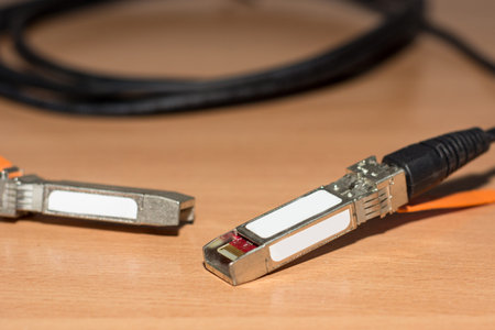 Direct attach copper cable for fast internet and network on wooden desk. Close up, selective focus