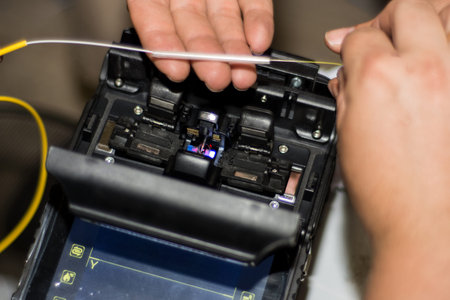 Fiber optic cable splicing by engineer with Optical Fiber Fusion Splicer instrument professional...