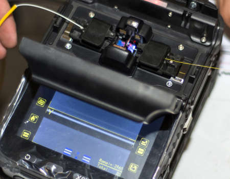 Splicing Fiber Optical Cable with Optical Fiber Fusion Splicer instrument professional tool. Modern and fast internet and network conceptの写真素材