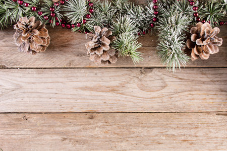 Christmas and New year holiday background with fir tree and pine cone with snow on wooden retro...