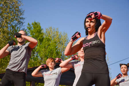 Nis, Serbia - April 20, 2019 Group of young people practicing pose under control of female Piloxing teacher outdoors on April 20, 2019 in park Sveti Sava, Nis, Serbia, Europeのeditorial素材