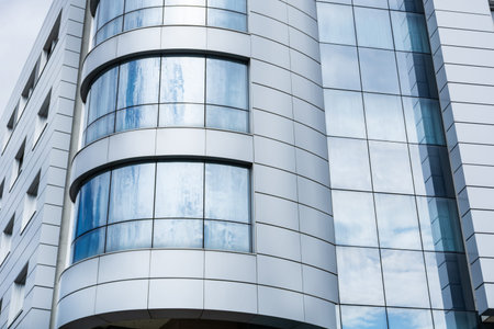 Modern building clean facade and windows with cloudy sky reflection. Modern architecture and...