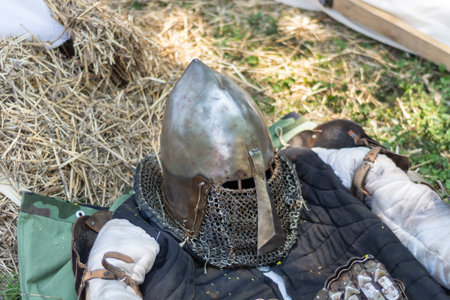 Medieval metal helmet on the floor. Old dark ages armor and equipment for knights head protection in...