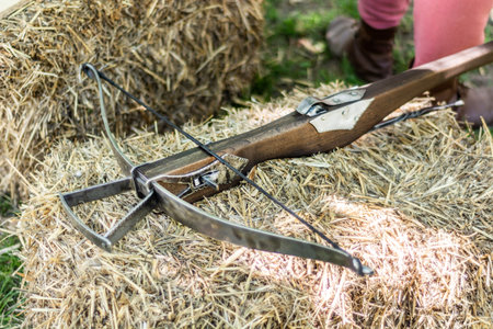 Medieval old crossbow without arrow exposed to a layer of hay at the festival of old medieval war...