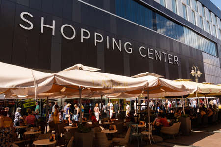 Nis, Serbia - August 28, 2019: Promenade street with cafes  and a big shopping center, people resting in a restaurant on summer sunny day in the city of Nis, Serbiaのeditorial素材