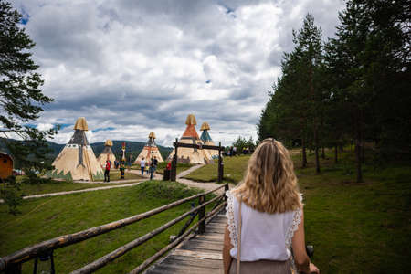 Zlatibor, Vodice, Serbia - July 26. 2020 Woman walking in direction of Indian village with tents in the city of El Paso in wild west style and cowboy style. Western thematic park. Traveのeditorial素材