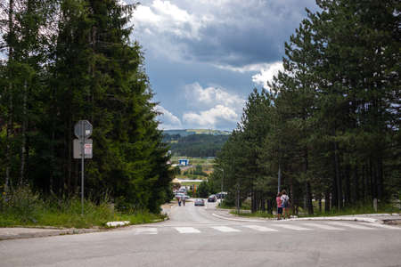 Zlatibor, Serbia - July 25. 2020 Asphalt road through dense pine forest and mountain with a dramatic sky in background in a natural resort on Zlatibor, Serbiaのeditorial素材